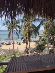 vistas a una playa con palmeras y al océano en Posada Ecohabitas, en Mazunte