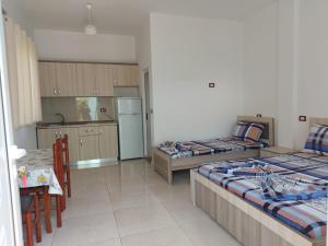 ein Wohnzimmer mit 2 Betten und eine Küche in der Unterkunft Summer Tale Rooms in Lezha