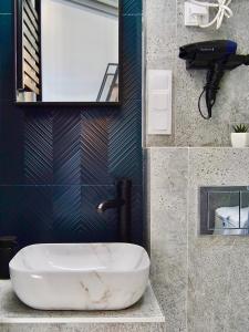La salle de bains est pourvue d'un lavabo blanc et d'un miroir. dans l'établissement Loft Apartments Gliwice, à Gliwice