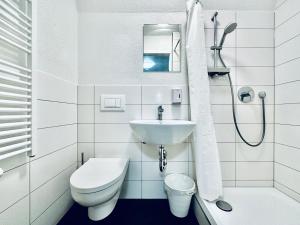 a white bathroom with a toilet and a sink at Monteurzimmer ZIMMERzuVERMIETEN in Balsthal Solothurn in Balsthal