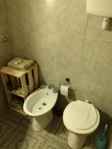 a bathroom with a white toilet and a sink at La Juana in Carmelo