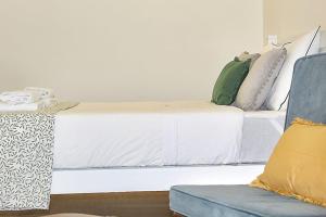 um quarto com uma cama branca e um sofá azul em Oporto Sweet Downtown 2 em Porto
