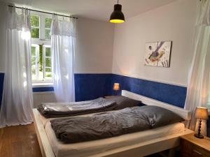 a bedroom with two beds and a blue wall at Flett - Artlands Home - Landhaus für Familien und Gruppen in Badbergen
