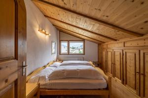 uma cama grande num quarto com tectos em madeira em Chesa Susi - Celerina em Celerina