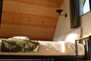 a bed in a room with a wooden ceiling at Cottage Milo Kazbegi in Stepantsminda