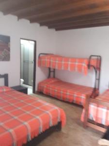モンテネグロにあるFinca Hotel El SAMAN de alto bonitoの二段ベッド2台と鏡が備わる客室です。
