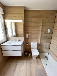a bathroom with a toilet and a sink and a shower at Apartamento Room Laredo in Laredo +14 photos