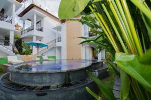 una piscina frente a un edificio con sombrilla en Lo Sari Bungalow, en Batununggul