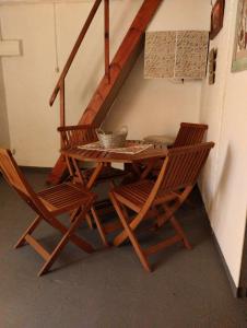 een houten tafel met 2 stoelen en een trap bij La Juana in Carmelo