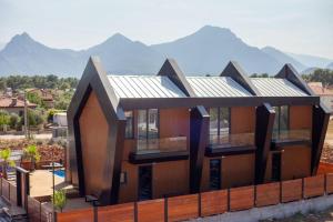 a house with a solar roof with mountains in the background at Boutique hotel with a heat pool in Dosemealti