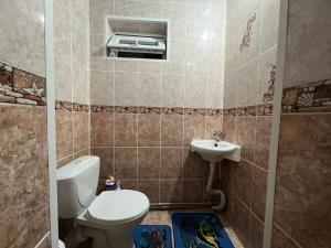a bathroom with a toilet and a sink at Guest House Dinara in Kaji-Say