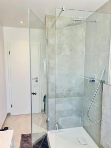 a shower with a glass door in a bathroom at City Apartments in Herzogenaurach