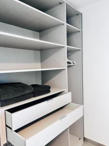 a walk in closet with white shelves at City Apartments in Herzogenaurach