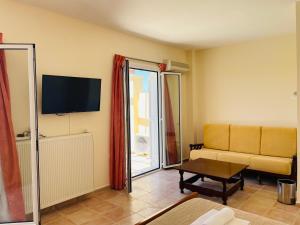 ein Wohnzimmer mit einem Sofa und einem TV in der Unterkunft Princess Of Crete in Skaleta