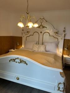 a bedroom with a large white bed with a chandelier at Studio-Apartment Rektor Suite 26 am Saseler Markt renoviert in Hamburg