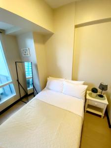 - une chambre avec un grand lit blanc et une fenêtre dans l'établissement Modern One Bedroom Condo at Mactan, Cebu, à Mactan