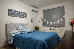 um quarto com uma cama azul e um cobertor azul em Casa Maria Luquillo PR em Luquillo