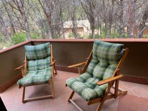 two rocking chairs sitting on a porch with at House pinus village in Forte Village