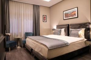 una camera d'albergo con un letto e due sedie di ARCHSTONE BY KETENCİ HOTEL a Konak