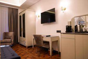 a hotel room with a desk and a tv on the wall at ARCHSTONE BY KETENCİ HOTEL in Konak