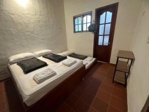 - une chambre avec un lit doté de draps blancs et d'oreillers noirs dans l'établissement Casa Victoria, à Zapatoca