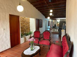 - un salon avec des chaises rouges et une table fleurie dans l'établissement Casa Victoria, à Zapatoca