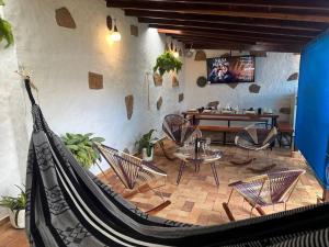 een kamer met stoelen en een hangmat in een kamer bij Casa Victoria in Zapatoca