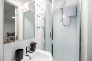 a bathroom with a sink and a shower at Newly refurbished Studio in Kensal green F in London