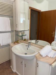 a white bathroom with a sink and a mirror at La Casa sul Lago Apartments - Olive Tree Apartment in Limone sul Garda