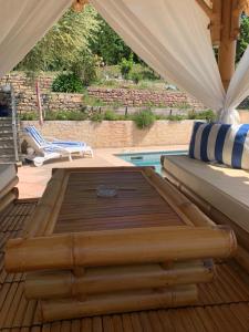 una cama de madera en una terraza junto a una piscina en Chalet de charme tout confort, en Les Adrets-de-l'Estérel