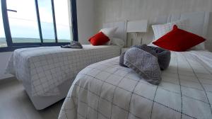 a bedroom with two beds with red and white pillows at The Panoramic Penthouse in Orihuela +97 photos