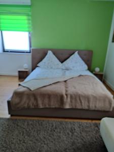 a bed in a bedroom with a green wall at Posträuberquartier in Gladenbach