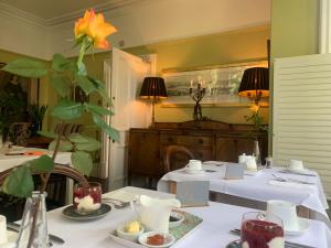 jadalnia z dwoma stołami z białymi obrusami w obiekcie Baytree House w mieście Harrogate