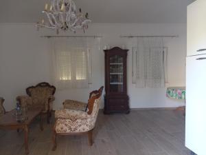 ein Wohnzimmer mit Stühlen, einem Tisch und einem Kronleuchter in der Unterkunft Guesthouse Adriatic in Biograd na Moru