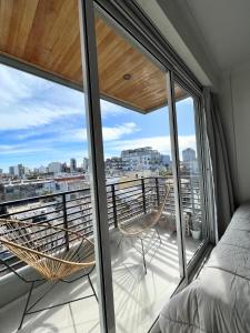 1 dormitorio con balcón con 1 cama y sillas en Monoambiente Luxury en Buenos Aires