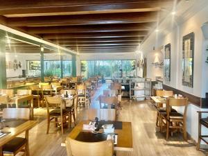 a restaurant with wooden tables and chairs and a cafeteria at Oscar Freire Hotel RDS Jardins in São Paulo