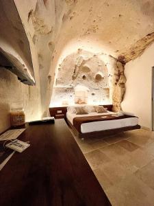 a bedroom with a bed in a stone wall at CASA VACANZE BB 164-166 in Matera