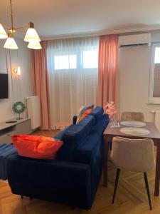 - un salon avec un canapé bleu et une table dans l'établissement Bella Casa Luxury Apartament, à Radom
