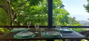 a table with plates and wine glasses on a balcony at Mountain and Sea view in Mileai