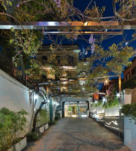 an alleyway with plants and lights at night at Best Western Cinemusic Hotel in Rome