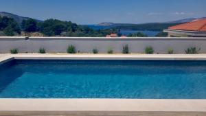 a swimming pool in front of a wall with a lake at Villa Bay View in Stari Grad