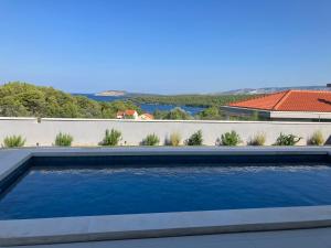 a swimming pool with blue water in front of a wall at Villa Bay View in Stari Grad