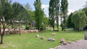 park z kamieniami w trawie i drzewach w obiekcie Chalet Suédois cocooning w mieście Chazelles