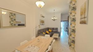 un soggiorno con tavolo e divano di Apartamentos TrianaSol a Siviglia