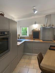 a kitchen with stainless steel appliances and a table at Gîte cosy in Orange