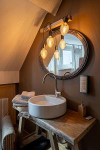 a bathroom with a sink and a mirror at Le Nid de la Canette in Durbuy +24 photos