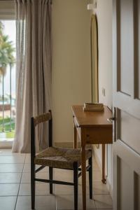 een houten bureau met een stoel naast een raam bij Erietta Aparthotel in Tsilivi