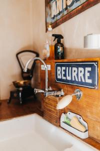 a kitchen sink with a beware sign above it at Le Nid de la Canette in Durbuy