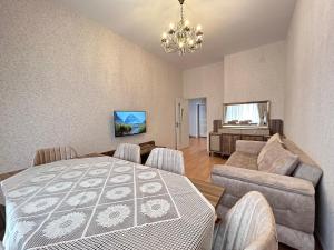 sala de estar con cama, sofá y lámpara de araña en White Stone Residence 47 en Bakú