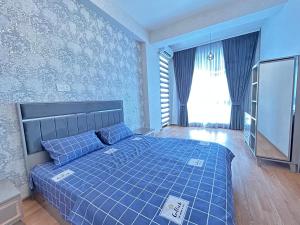 Dormitorio azul con cama y ventana en White Stone Residence 47 en Bakú